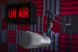 Professional microphone in radio station studio and on air sign